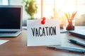 Ã¢â¬ÅVacationÃ¢â¬Â note on office desk. Laptop supplies, blurred background Royalty Free Stock Photo